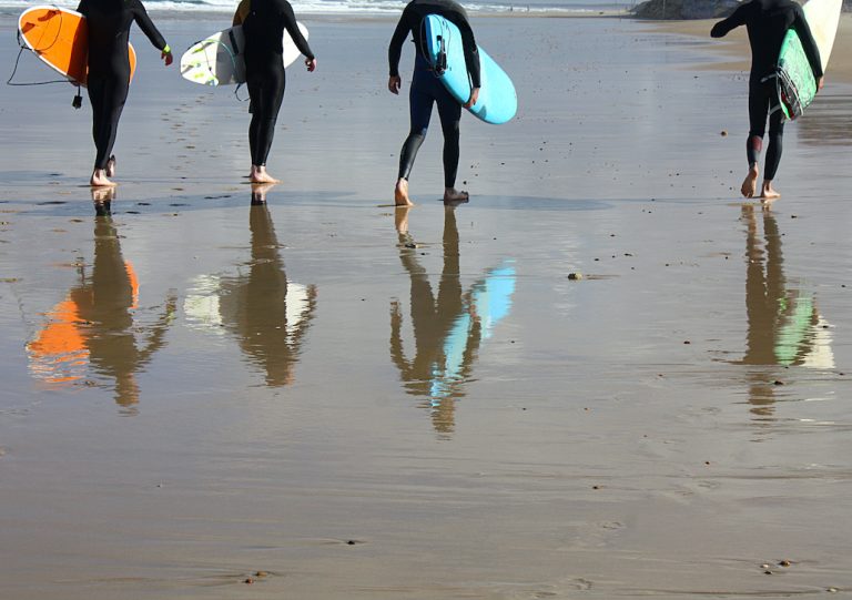 Surfers walking on the beach in Devon