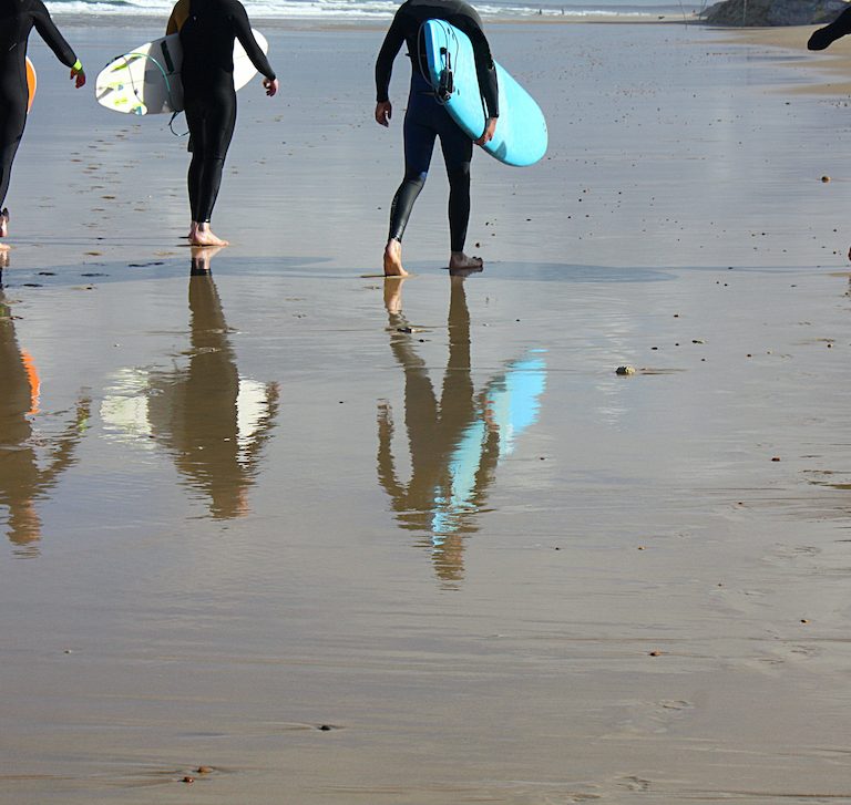 Surfers walking on the beach in Devon