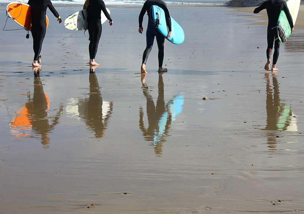 Surfers walking on the beach in Devon